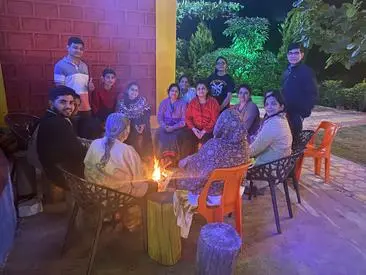 Family guest enjoying bonfire with music at shivsagar agro tourism tapola